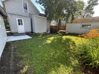 a yard with a house and a bench in the yard at Strikeout All Star Baseball Rentals in Oneonta