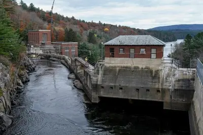 a bridge over a river with a building on it at Adirondack Spirit in Gloversville
