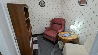 a living room with a red chair and a table at Adirondack Spirit in Gloversville