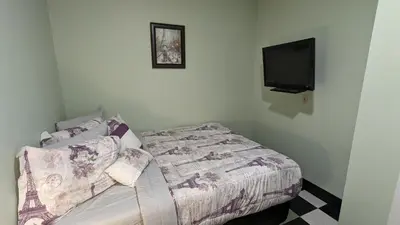 a bedroom with a bed and a flat screen tv at Adirondack Spirit in Gloversville