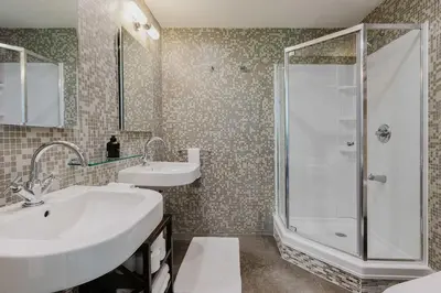 a bathroom with two sinks and a shower at Designer Home in Diplomat District in New York