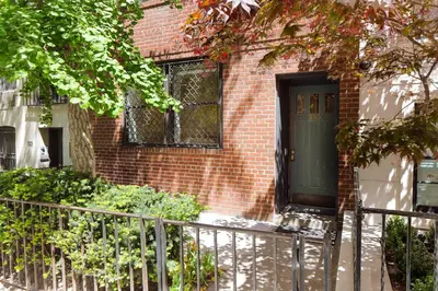 a brick house with a green door and a fence at Designer Home in Diplomat District in New York