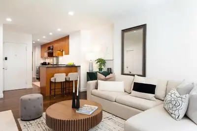 a living room with a couch and a table at Designer Home in Diplomat District in New York