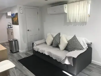 a couch with pillows on it in a living room at 25-30 mins to Times Sq! in Corona