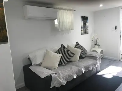 a couch with pillows on it in a living room at 25-30 mins to Times Sq! in Corona