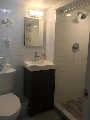 a bathroom with a sink and a toilet and a mirror at 25-30 mins to Times Sq! in Corona