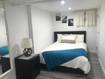 a bedroom with a bed with a blue blanket at 25-30 mins to Times Sq! in Corona