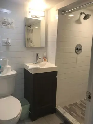 a bathroom with a sink and a toilet and a mirror at 25-30 mins to Times Sq! in Corona