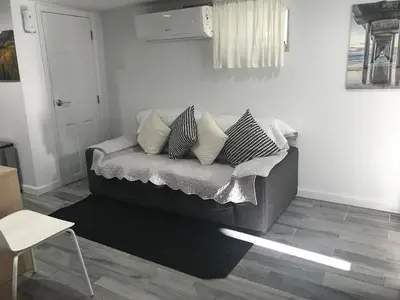 a living room with a couch with pillows on it at 25-30 mins to Times Sq! in Corona