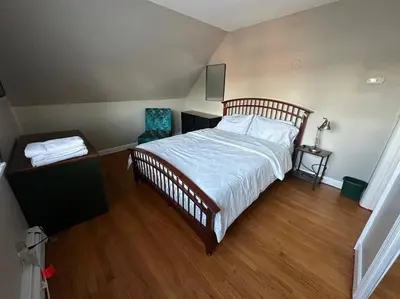 a bedroom with a large bed and a wooden floor at Stunning 4BR home close to NYC in Teaneck