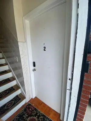 a white door with a number on it next to a staircase at Live in NYC -20 Mins to Rockefeller, MoMA & World in Jersey City