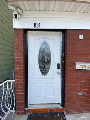 a white door with a window on a brick building at Live in NYC -20 Mins to Rockefeller, MoMA & World in Jersey City