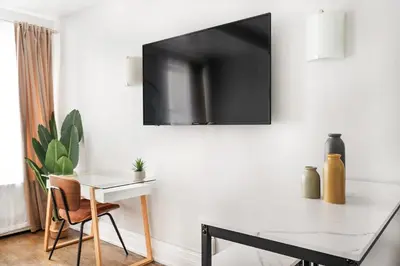 a dining room with a table and a tv on a wall at 73-703 New Studio UWS Doorman Gym in New York