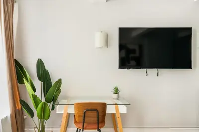 a desk with a chair and a television on a wall at 73-703 New Studio UWS Doorman Gym in New York