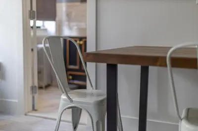 a white chair sitting at a wooden table at Manhattan Bridge-Brooklyn-UN Private Suite Bath in Brooklyn