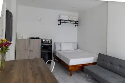 a bedroom with a bed and a couch and a table at Manhattan Bridge-Brooklyn-UN Private Suite Bath in Brooklyn