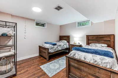 two twin beds in a room with wooden floors at Cozy Wooded Retreat Big Bass Lake Home in Lehigh