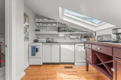a kitchen with white cabinets and a stove at Studio Flat Above Historic Cider Mill in Westport