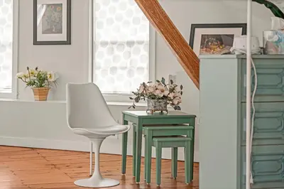a table and chair with a vase of flowers on it at Studio Flat Above Historic Cider Mill in Westport