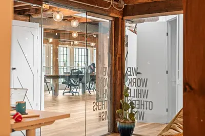 an open office with glass doors and a table at Studio Flat Above Historic Cider Mill in Westport