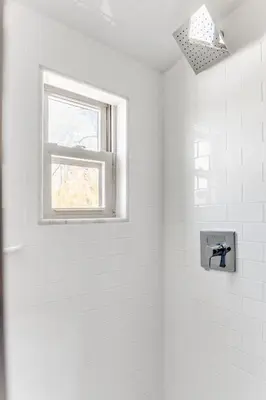 a white bathroom with a shower with a window at 2BR Flat above Historic Cider Mill in Westport