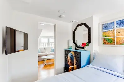 a bedroom with a bed and a mirror at 2BR Flat above Historic Cider Mill in Westport