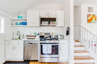 a kitchen with white cabinets and a stove at 2BR Flat above Historic Cider Mill in Westport