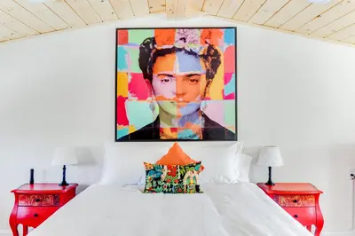 a bedroom with a white bed with a painting on the wall at 2BR Flat above Historic Cider Mill in Westport