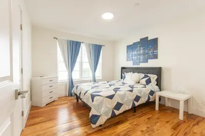 a bedroom with a bed and a wooden floor at Divine Essence in Newark
