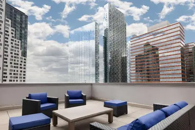 a balcony with chairs and a view of a city at Hilton Garden Inn Long Island City in Queens