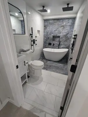 a bathroom with a tub and a toilet and a sink at Luxury Apt in Passaic