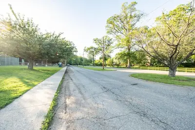 an empty road in a park with trees at Luxury Apt in Passaic