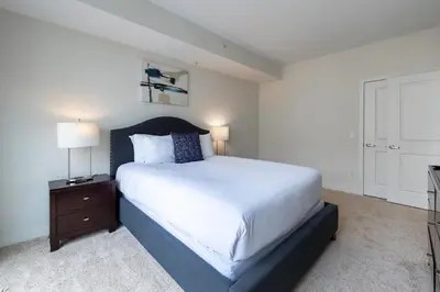 a bedroom with a large white bed and a nightstand at Luxury Apt In Harbor Point with Balcony in Stamford