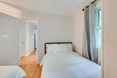 a white bedroom with a bed and a window at Becket Home with 3-Season Porch Walk to Lake Access in Becket