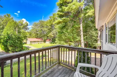 a deck with two chairs and a view of a yard at Becket Home with 3-Season Porch Walk to Lake Access in Becket