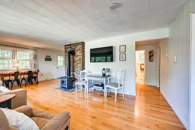 a living room with a table and a dining room at Becket Home with 3-Season Porch Walk to Lake Access in Becket