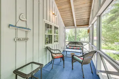 a porch with chairs and a table on it at Becket Home with 3-Season Porch Walk to Lake Access in Becket