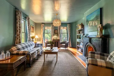 a living room with a couch and a fireplace at Wilder House Berkshires in Sheffield