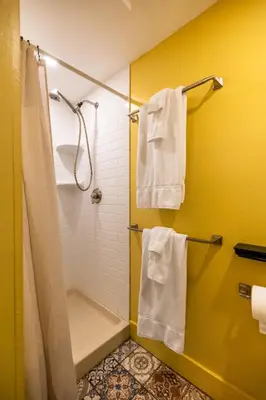 a bathroom with a shower and white towels at Wilder House Berkshires in Sheffield
