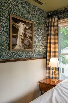 a bedroom with a picture of a cow on the wall at Wilder House Berkshires in Sheffield