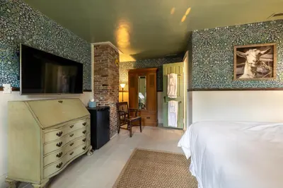 a bedroom with a bed and a dresser with a television at Wilder House Berkshires in Sheffield