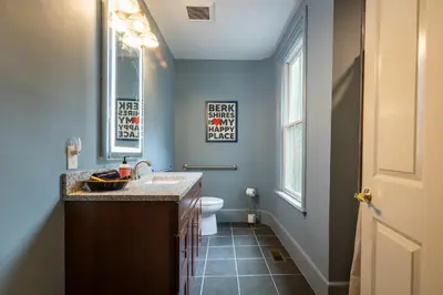 a bathroom with a sink and a toilet and a window at Wilder House Berkshires in Sheffield