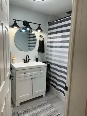 a bathroom with a sink and a shower with a mirror at 3BR, 2BA and Office Fire Pit,Mins 2 UConn & Lake in Coventry