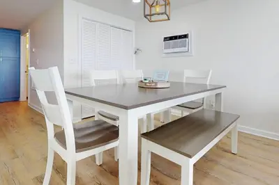a dining room with a table and white chairs at Charming 3 bedroom Beach Front Cottage in Milford