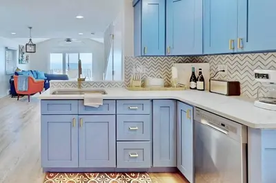a kitchen with blue cabinets and a counter top at Charming 3 bedroom Beach Front Cottage in Milford