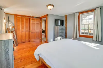 a bedroom with a white bed and a kitchen at Walk to Memorial Park Pet-Friendly Bethlehem Home in Bethlehem