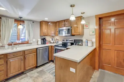 a kitchen with wooden cabinets and a counter top at Walk to Memorial Park Pet-Friendly Bethlehem Home in Bethlehem
