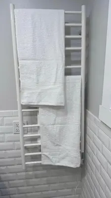 a towel rack with white towels in a bathroom at Modern and Cozy Pine Hills Home from Early 1900s in Albany