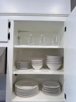 a white cabinet filled with plates and glasses at Modern and Cozy Pine Hills Home from Early 1900s in Albany