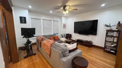 a living room with a couch and a flat screen tv at Modern and Cozy Pine Hills Home from Early 1900s in Albany